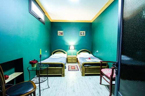 2 camas en una habitación con paredes verdes en MGA Hostel & Tours, en Ereván
