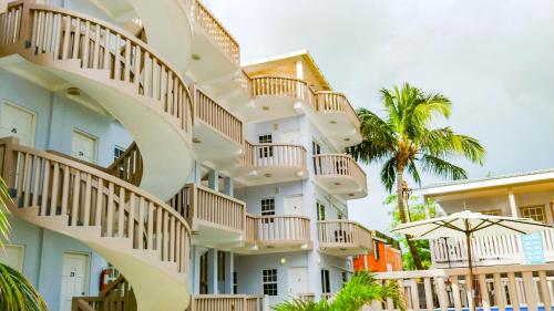 an apartment building with spiral stairs and an umbrella at La Isla Resort in Caye Caulker