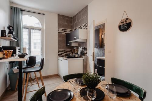 - une cuisine et une salle à manger avec une table et des chaises dans l'établissement Les Appartements Hyper Centre Valenciennes, à Valenciennes