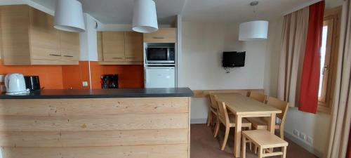 a kitchen with a counter and a table and chairs at Apt With Garden In La Plagne in La Plagne