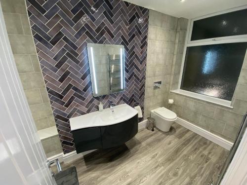 a bathroom with a sink and a toilet at Edward Place Luxury Hot Tub Apartments in Blackpool