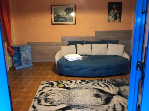 sala de estar con sofá azul y cama en Andrebyke terrace en Gergei