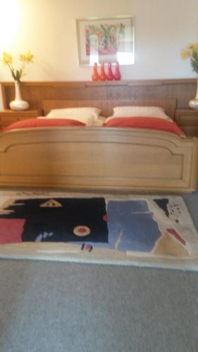 a bedroom with a large wooden bed with a blanket at Ferienwohnung Villa Bella Vista in Bad Sachsa