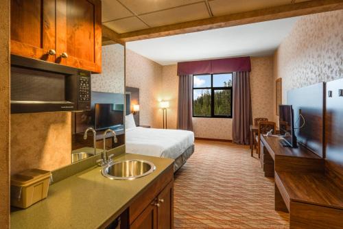 a hotel room with a bed and a kitchen with a sink at The Lodge at Big Sky in Big Sky