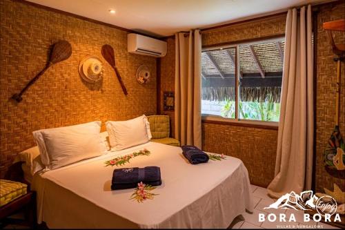 - une chambre avec un lit fleuri dans l'établissement Villa Bora Bora - on Matira, à Bora Bora