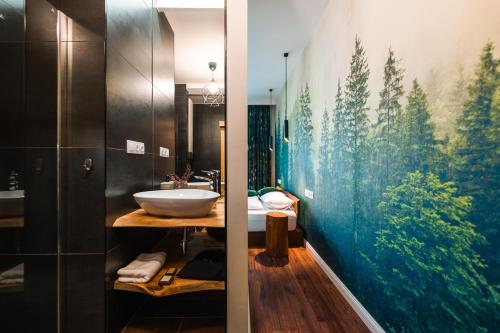 baño con lavabo y una gran pintura en la pared en Cserszegi Kockák, en Cserszegtomaj