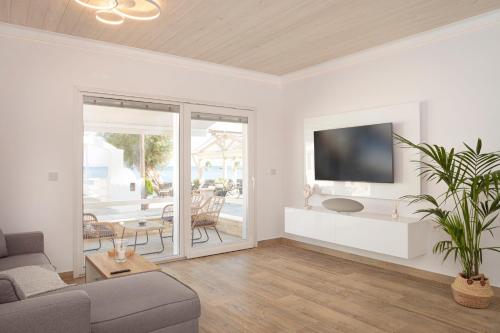 un soggiorno con divano e TV di ETHOS Luxury Home - Seaview Villa with Hot-Tub! a Iraion