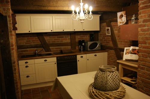 a kitchen with white cabinets and a vase on a table at Eifelhoeve in Benenberg in Hellenthal