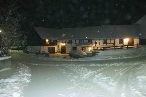 a house is covered in snow at night at Eifelhoeve in Benenberg in Hellenthal