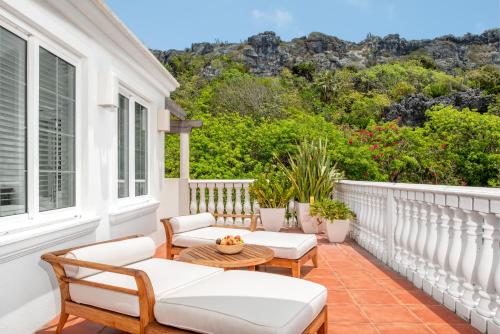 a balcony with white furniture and a table and chairs at Le Soleil D'or in Cayman Brac