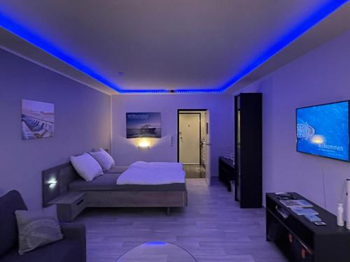 a living room with a couch and a tv at Themenpartment Himmel und Mehr Penthouse in Gelsenkirchen