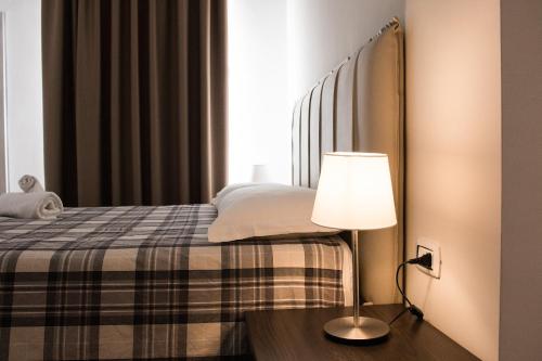 a bedroom with a bed and a lamp on a table at BARBAJA SUITES IN STREET TOLEDO 205 in Naples