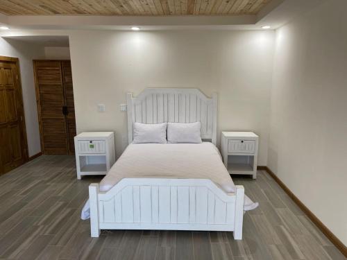 a bedroom with a white bed with two night stands at Maple Resort in Santa Rosa