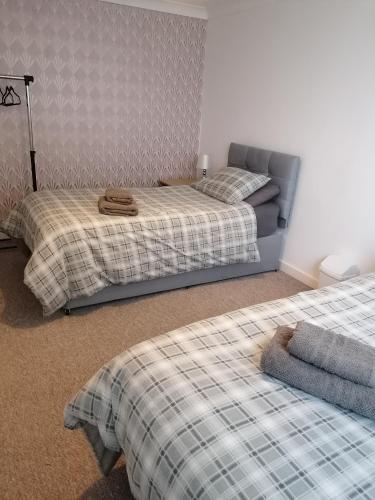 two beds in a room with two beds sidx sidx sidx at Bathgate Handy House in Bathgate