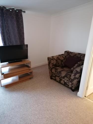 a living room with a tv and a couch at Bathgate Handy House in Bathgate