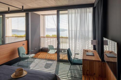 - une chambre avec un lit, un bureau et un balcon dans l'établissement Hotel Osmolis, à Zaton