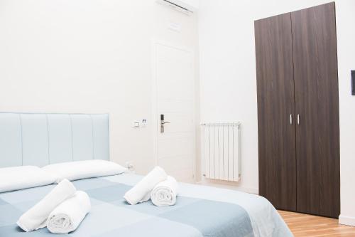 a white bedroom with two beds and a brown cabinet at BARBAJA SUITES IN STREET TOLEDO 205 in Naples