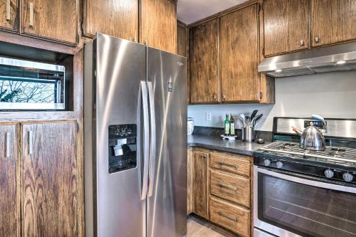 a kitchen with a stainless steel refrigerator and wooden cabinets at Luxe Lake Arrowhead Getaway with Treetop Views! in Lake Arrowhead