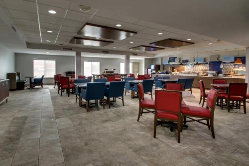 a dining room with tables and chairs in a restaurant at Holiday Inn Express Hotel & Suites Waukegan/Gurnee by IHG in Waukegan
