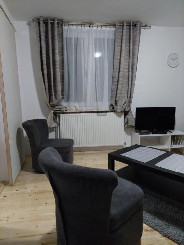 a living room with two chairs and a table at Apartman Centar in Kragujevac