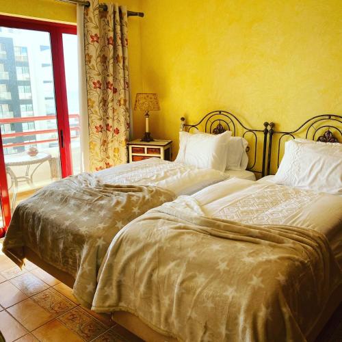 two beds sitting next to each other in a bedroom at Castelo I in Quarteira