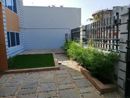 a courtyard of a building with a fence and grass at IMOLEASE HUBERT Sainte Rita in Cotonou