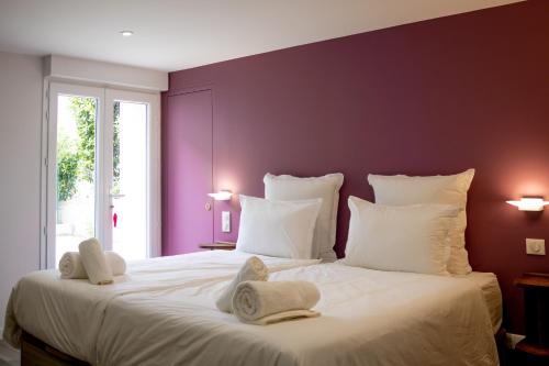 En eller flere senge i et værelse på Villa du Marché