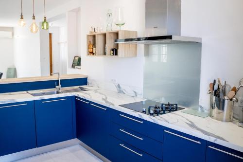 a kitchen with blue cabinets and a sink at Villa du Marché in Royan
