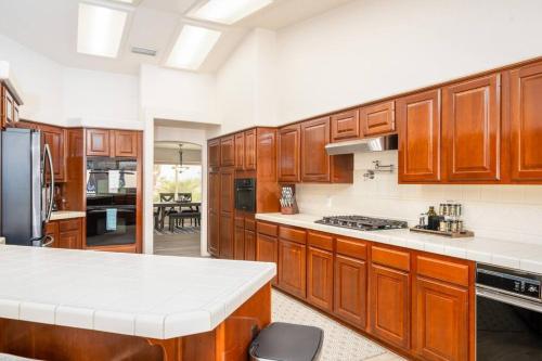 a large kitchen with wooden cabinets and white counter tops at Grand Havasu Oasis with Custom Pool & Spa! in Lake Havasu City