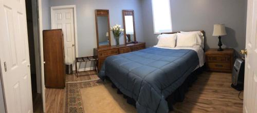 a bedroom with a blue bed and a mirror at Single family home in Fort Washington