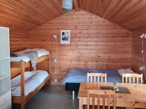 a room with two bunk beds and a table at Sonfjällscampen in Hede
