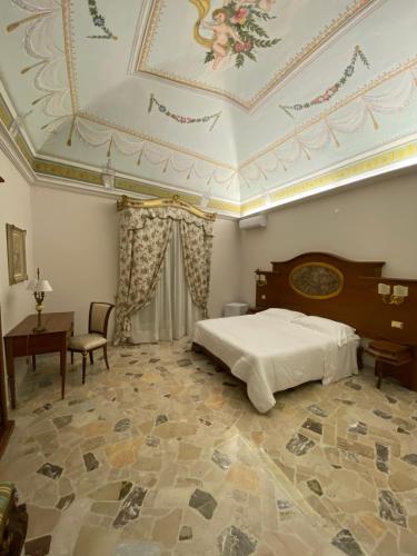 - une chambre avec un lit et un plafond à caissons dans l'établissement Terebinto, à Bronte