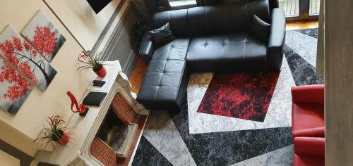 an overhead view of a living room with a black leather couch at Guesthouse Marie Therese in Brussels