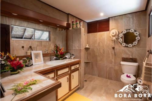 a bathroom with a toilet and a sink at Villa Bora Bora - on Matira in Bora Bora