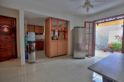 uma cozinha com um frigorífico de aço inoxidável num quarto em EXCELENTE CASA EM CABO FRIO - BRAGA em Cabo Frio