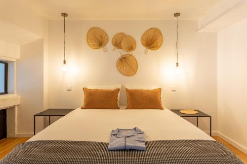 a bedroom with a bed with a shirt on it at Bairro Alto Bronze of Art Apartments in Lisbon