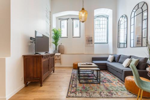 a living room with a couch and a tv at Bairro Alto Bronze of Art Apartments in Lisbon