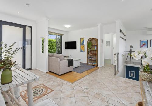 a living room with a couch and a television at Beachfront Paradise - Jones Beach in Minnamurra