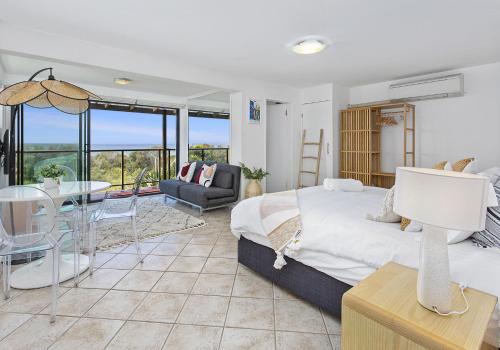 a bedroom with a large bed and a living room at Beachfront Paradise - Jones Beach in Minnamurra