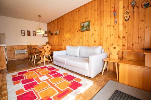 uma sala de estar com um sofá branco e uma cozinha em A un passo dagli impianti - Penia di Canazei em Penia