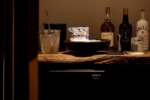 a counter with bottles of wine and a bowl on it at MARUYO HOTEL in Kuwana