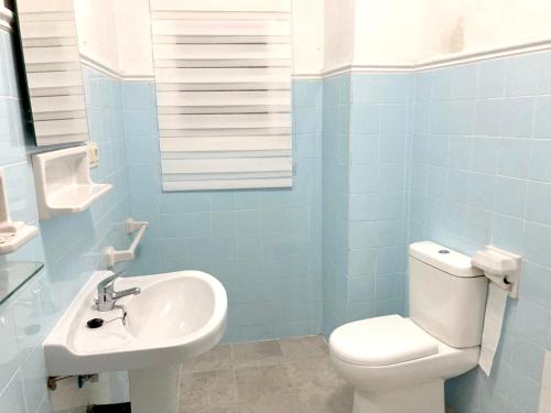 a bathroom with a white toilet and a sink at 4 bedrooms house with terrace and wifi at Albunol 7 km away from the beach in Albuñol