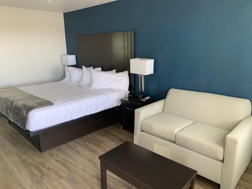 um quarto de hotel com uma cama e um sofá em GreenTree Inn of Holbrook, AZ em Holbrook