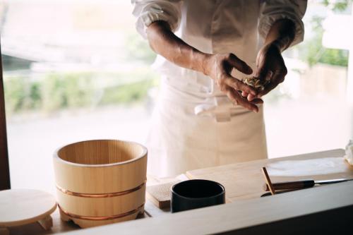 a chef standing in a kitchen preparing food at MARUYO HOTEL in Kuwana