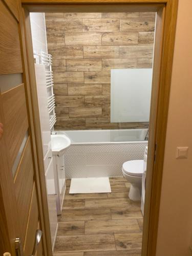 een badkamer met een toilet, een bad en een wastafel bij Bengal Apartments in Szczecin