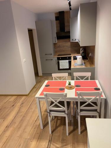 een keuken met een tafel en stoelen in een kamer bij Bengal Apartments in Szczecin