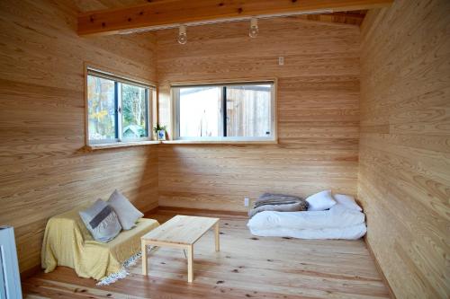 Cabaña de madera con cama y mesa. en Yatsugatake Little Village Hotel, en Hara