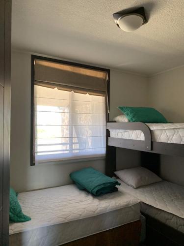two bunk beds in a room with a window at Departamento Costa Pucón 403 in Pucón