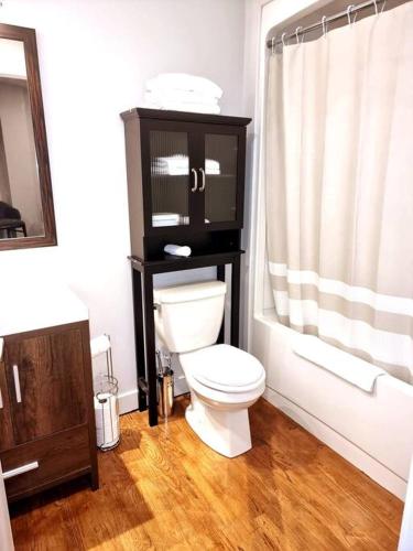 a white bathroom with a toilet and a shower at Cozy Sweet Studio #1, 10 minutes to D.T. Ottawa in Gatineau