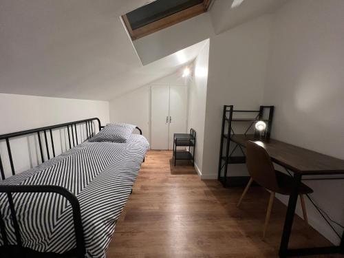 a bedroom with a bed and a table and a desk at BEAU T3 STYLE INDUSTRIEL N20 ORLY PARIS WIFI Underground Industry in La Ville-du-Bois